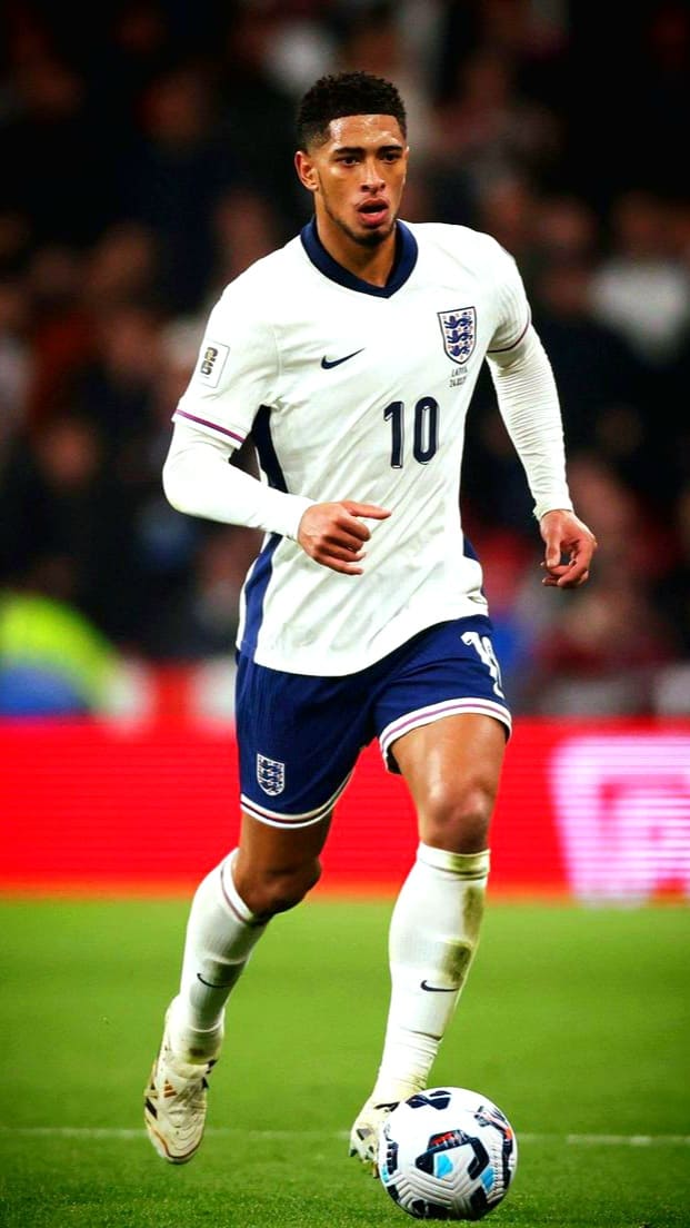 A male soccer player in an England national team uniform, wearing the number 10 jersey, runs on the field while dribbling a soccer ball during a match broadcasted on IPTV Latino.